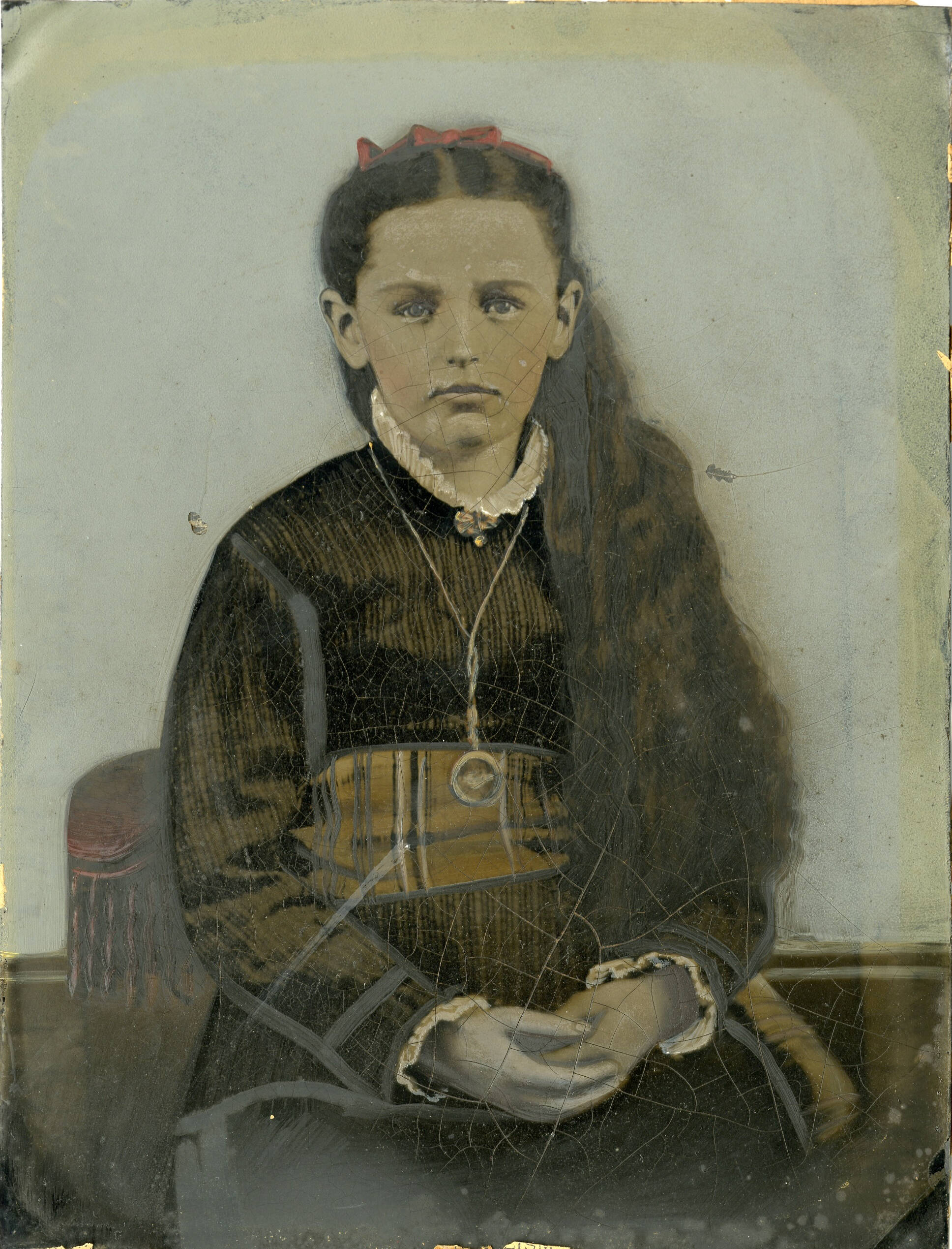 Tintype photograph that has been hand-colored. Image is of a young woman with long hair.